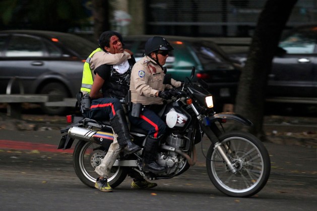 National police transport a detainee after an anti-government protest at Altamira square in Caracas