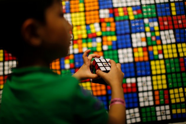 A boy plays with the Rubik's cube during an event to mark the 40th anniversary of the puzzle toy at the Liberty Science Center in Jersey City