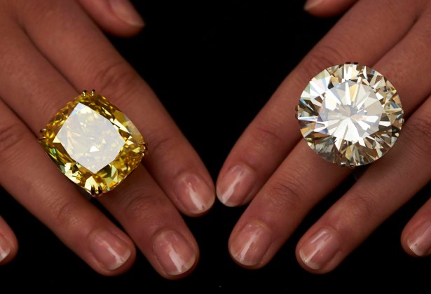 Una modelo posa con un vívido amarillo 100,09 quilates de diamantes (L) y un anillo de 103,46 quilates de diamantes durante una vista previa de la subasta en Sotheby en Ginebra / Denis Balibouse / Reuters