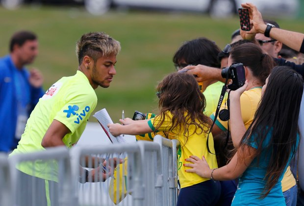 Brazil's Neymar signs autographs after a training session in Teresopolis near Rio de Janeiro