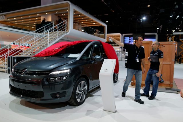 An employee prepares a Citroen C4 car which is displayed at French carmaker Citroen showcase for the Paris Mondial de l'Automobile