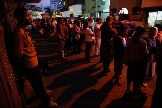 Un grupo de personas hace fila para comprar papel higiénico en un supermercado en Caracas