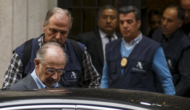 Rato, former People's Party minister and former managing director of the International Monetary Fund, enters a police's car as they leave his residence after an inspection in Madrid