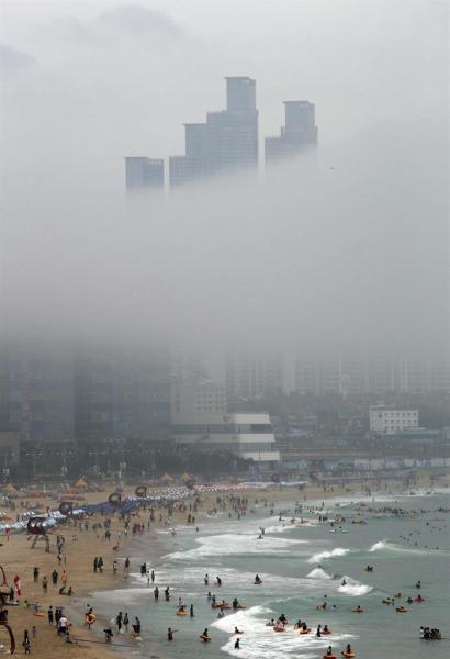 Torres de apartamentos se perfilan entre la niebla junto a la playa Haeundae en la ciudad portuaria de Busan (Corea del Sur), hoy, 22 de julio de 2015. EFE/Yonhap 