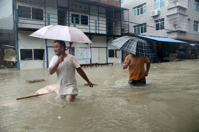 People wade through a flooded street at a town hit by Typhoon Soudelor in Ningde