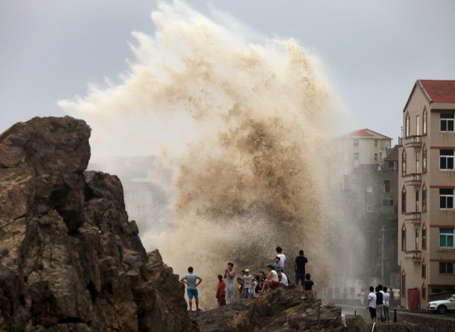 Un grupo de personas mira las olas provocadas por le tifón Soudelor, mientras se acerca a China, en Tizhou, provincia de Zhejiang, el 8 de agosto de 2015.  Un poderoso tifón azotó Taiwán el sábado con fuertes vientos y lluvias torrenciales, dejando seis muertos y 3,62 millones de hogares sin electricidad. REUTERS/Stringer