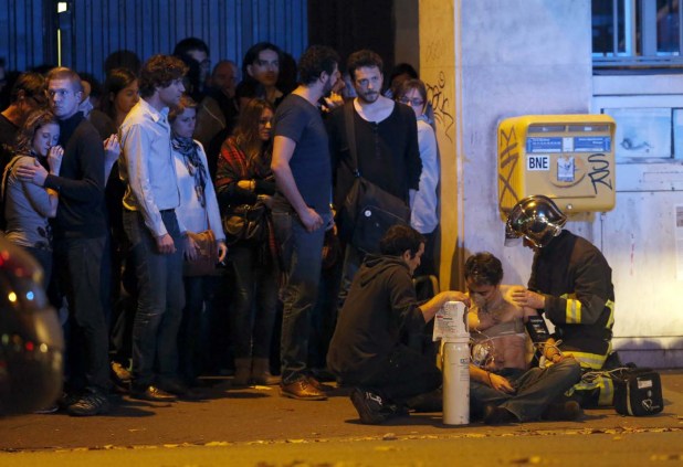 ATTENTION EDITORS - VISUAL COVERAGE OF SCENES OF INJURY OR DEATH  A member of the French fire brigade aids an injured individual near the Bataclan concert hall following fatal shootings in Paris, France, in this November 13, 2015 file photo.   REUTERS/Christian Hartmann/Files