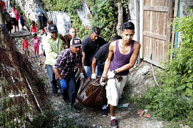 Un grupo traslada los cuerpos de hombres que fueron asesinados por jóvenes armados tras ser sacados de sus casas en en una barriada de Tegucigalpa, Honduras, el miércoles 25 de noviembre de 2015. Siete personas fueron asesinadas a tiros en un barrio conocido como el "Infiernito" en Tegucigalpa y ocho conductores de buses de pasajeros fueron asesinados en una estación de transporte en la ciudad de Choloma, próxima a San Pedro Sula en el norte del país del martes 24 de noviembre de 2015.(AP Photo/Fernando Antonio)