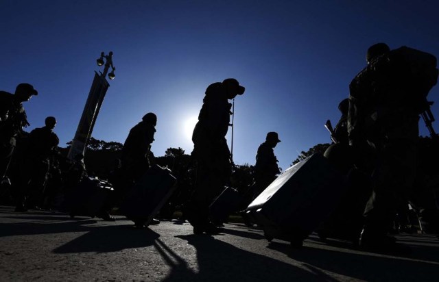 Members of the Venezuelan army walk with electoral machines in Caracas on December 1, 2015. The Venezuelan opposition on Monday urged the armed forces to ensure that the results of the legislative elections of next Sunday are respected. AFP PHOTO/JUAN BARRETO / AFP / JUAN BARRETO