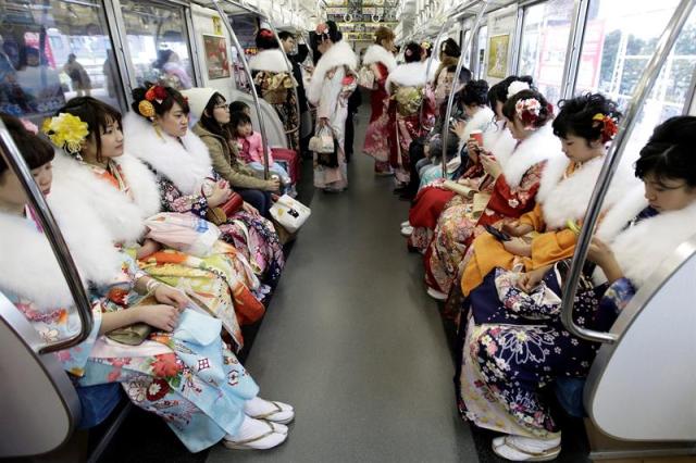 Jóvenes japonesas ataviadas con coloridos kimonos viajan en el vagón de un tren tras asistir a su ceremonia de mayoría de edad en el parque de atracciones Toshimaen en Tokio (Japón), el 11 de enero de 2016. Con la ceremonia de mayoría de edad se celebra el comienzo de la edad adulta para aquellos que cumplen 20 años, edad con la alcanzan el derecho de ejercer su derecho al voto, beber o fumar. EFE/Kiyoshi Ota