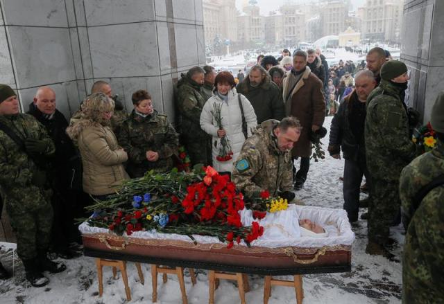 Ucranianos dan su último adiós al capitán de policía Oleksandr Ilnytsky durante su funeral en la Plaza de la Independencia de Kiev (Ucrania), el 11 de enero de 2016. Dos soldados ucranianos han muerto en las últimas 24 horas en la región oriental de Donetsk en escaramuzas entre las fuerzas gubernamentales y las milicias prorrusas, que amenazan la tregua navideña declarada a finales del pasado año. Ucrania acusa a las fuerzas de la autoproclamada república popular de Donetsk de violar los Acuerdos de Paz de Minsk al romper el cese del fuego y utilizar armamento prohibido, desde morteros y ametralladoras de gran calibre, a tanques y blindados. Por su parte, los separatistas reconocieron una baja en sus filas, un miliciano que fue abatido anoche por un francotirador enemigo al norte de Górlovka. EFE/Sergey Dolzhenko