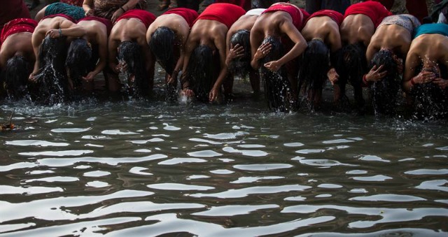 Mujeres nepalíes toman un baño sagrado en el río Hanumante durante el festival de Madhav Narayan en Bhaktapur a las afueras de Katmandú (Nepal) hoy, 22 de febrero de 2016. El Festival de Madhav Narayan se celebra durante un mes en el que se ayuna, se toman baños sagrados y se estudia el libro Swasthani, una historia leida cada noche por sacerdotes y creyentes en familia. Cientos de matrimonios ayunan durante un mes por una vida mejor y paz en el país, mientras que mujeres solteras ayunan para conseguir un buen marido. EFE/Narendra Shrestha