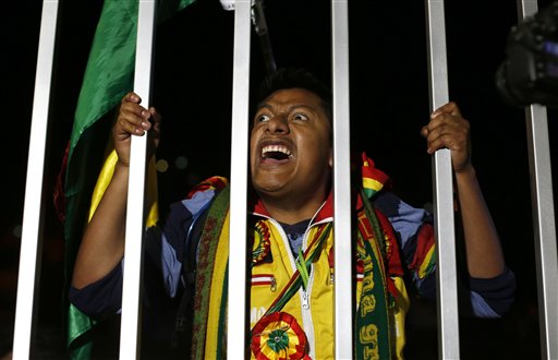 En esta imagen del martes 23 de febrero de 2016, un manifestante corea lemas contra el presidente de Bolivia, Evo Morales, exigiendo que admita la derrota, mientras espera a los resultados oficiales de un referendo constitucional ante un centro de votación en La Paz, Bolivia. Con el 95% de los votos contados el martes, los resultados indicaban que el 52% de lso electores rechazó la propuesta de Morales de cambiar la constitución para poder presentarse a un cuarto mandato en 2019. (AP Foto/Juan Karita)