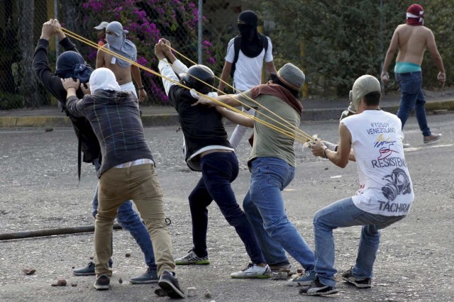 Student demonstrators use a slingshot to throw rocks at police during a protest against Venezuelan President Nicolas Maduro's government in San Cristobal, Venezuela, March 10, 2016. REUTERS/Carlos Eduardo Ramirez FOR EDITORIAL USE ONLY. NO RESALES. NO ARCHIVE.