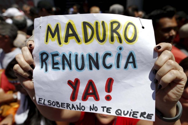 An opposition supporter holds a sign that reads "Maduro resigns now. The sovereign does not love you", during a rally against Venezuela's President Nicolas Maduro's government in Caracas March 12, 2016. REUTERS/Carlos Garcia Rawlins/Files