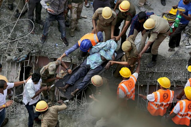  Miembros de la Fuerza de Respuesta de Desastres Nacionales (NDRF) trabajan para rescatar a las víctimas de un derrumbe en Calcuta (India) hoy, 31 de marzo de 2016. Decenas de personas permanecen atrapadas entre los escombros de un paso a desnivel que se derrumbó hoy parcialmente en la ciudad de Calcuta, en el este de la India, informó a Efe una fuente oficial. Las autoridades calculan que hay un centenar de atrapados, dijo una fuente de la Policía local, que agregó que las labores de rescate están en marcha y que todavía se desconoce si se han producido víctimas mortales. EFE/Piyal Adhikary