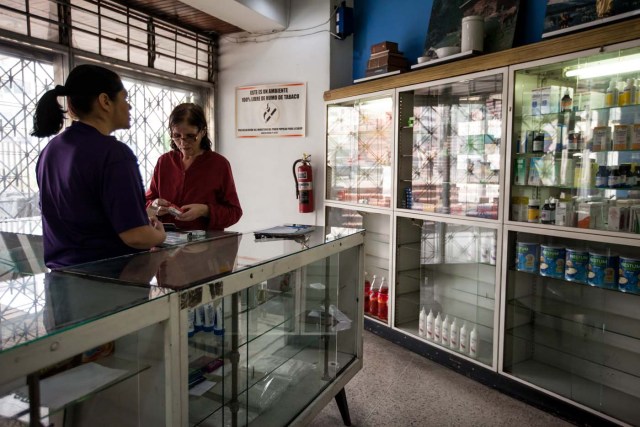 ACOMPAÑA CRÓNICA: VENEZUELA SALUD CAR35. CARACAS (VENEZUELA), 14/04/2016.- Beatriz Gorostiza (i), una de las encargadas de la farmacia "San Vicente", atiende a una cliente este, jueves 14 de abril del 2016, en la ciudad de Caracas (Venezuela). La escasez de medicamentos en Venezuela sigue siendo una tragedia visible en farmacias y hospitales, semanas después de que el Parlamento declarara una "crisis humanitaria de salud" que, entre otros cosas, se estaría manifestando en la falta de disponibilidad de 872 fármacos esenciales. EFE/MIGUEL GUTIÉRREZ