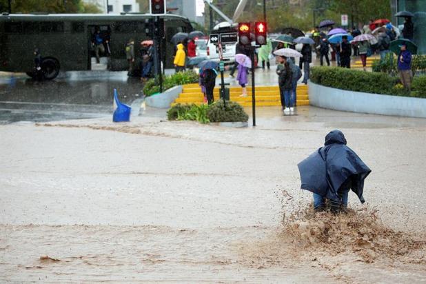 Un hombre en bicicleta intenta cruzar una calle inundada hoy, domingo 17 de abril de 2016, debido a las lluvias en la región metropolitana, donde la autoridad ha decretado "alerta roja", cuando más de cuatro millones de personas se encuentran sin suministro de agua potable, y cientos de calles se encuentran intransitables. Al menos un muerto, cinco desaparecidos, un millar de damnificados, crecidas de ríos y varios aludes es el saldo que ha dejado el temporal de viento y lluvia que afecta desde este sábado la zona central de Chile. EFE/Mario Ruiz