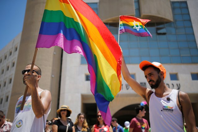 Revellers observe a minute's silence in memory of the victims of the Pulse gay nightclub shooting in Orlando, Florida, during a gay pride parade in the southern city of Ashdod, Israel, June 17, 2016. REUTERS/Amir Cohen