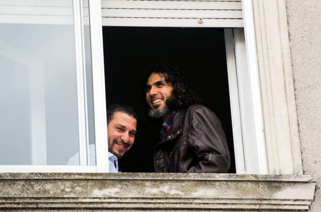 Foto de 5 de junio de 2015, Abu Wa'el Dhiab, de Siria, a la derecha, y Adel bin Muhammad El Ouerghi, de Túnez, ambos liberados los detenidos de Guantánamo, de pie junto a la ventana de su hogar compartido en Montevideo, Uruguay. Matilde Campodónico AP 