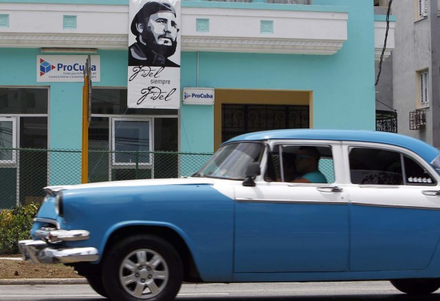 HAB116. LA HABANA (CUBA), 12/08/2016.- Un vehículo pasa hoy, viernes 12 de agosto del 2016, junto a un cartel del líder de la revolución cubana Fidel Castro, en La Habana (Cuba). Fidel Castro cumple 90 años y aunque la fecha exacta es el 13 de agosto, Cuba lleva ya meses celebrando este hito con homenajes como la composición de una sinfonía, una página web, la apertura de lugares de interés histórico e incluso una peregrinación en bicicleta hasta el pueblo natal del expresidente. EFE/Ernesto Mastrascusa