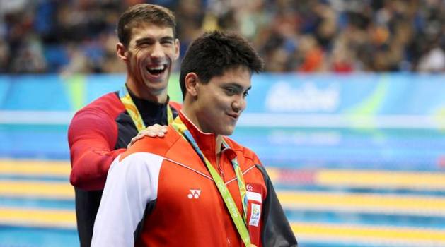 2016 Rio Olympics - Swimming - Victory Ceremony - Men's 100m Butterfly Victory Ceremony - Olympic Aquatics Stadium - Rio de Janeiro, Brazil - 12/08/2016. Joseph Schooling (SIN) of Singapore is congratulated by Michael Phelps (USA) of USA as they leave the podium. REUTERS/Stefan Wermuth FOR EDITORIAL USE ONLY. NOT FOR SALE FOR MARKETING OR ADVERTISING CAMPAIGNS.