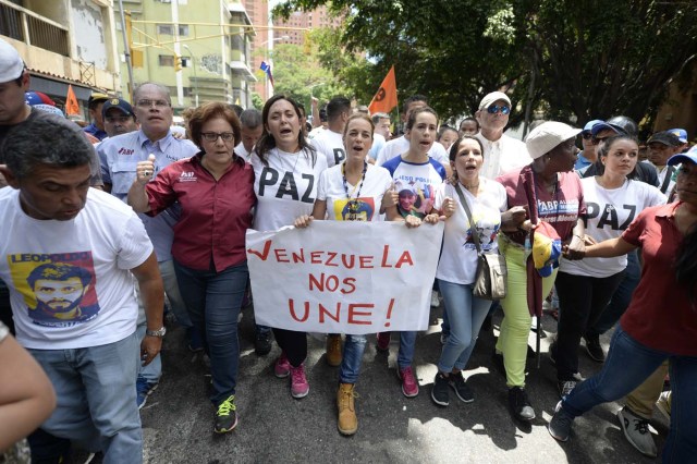 Venezuelan opposition leader Lilian Tintori (C) participates in a march in Caracas on September 16, 2016 demanding to the government to set the date for a recall referendum against President Nicolas Maduro. The Venezuelan opposition's push for a vote to remove President Maduro ran into a roadblock Thursday when authorities announced a delay in setting the date for the final stage in the process. / AFP PHOTO / FEDERICO PARRA