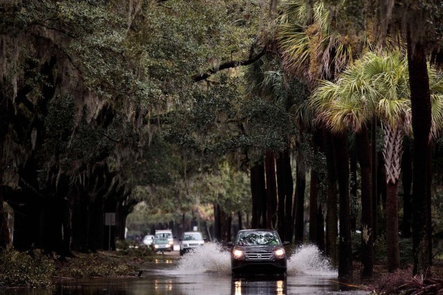 SAVANNAH, GA - OCTOBER 8: A car drives through water on a lightly flooded road, October 8, 2016 in Savannah, Georgia. Across the Southeast, Over 1.4 million people have lost power due to Hurricane Matthew which has been downgraded to a category 1 hurricane on Saturday morning. Drew Angerer/Getty Images/AFP