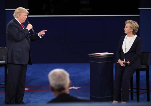 Donald Trump speaks as Hillary Clinton listens. REUTERS/Jim Young