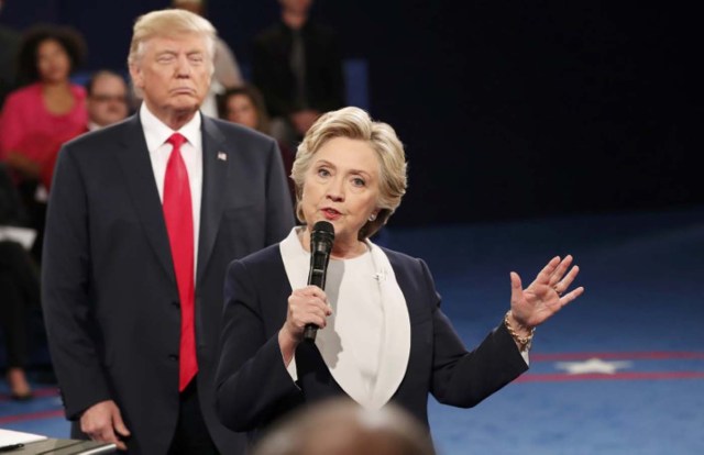 Republican U.S. presidential nominee Donald Trump listnes as Democratic nominee Hillary Clinton answers a question from the audience during their presidential town hall debate at Washington University in St. Louis, Missouri, U.S., October 9, 2016. REUTERS/Rick Wilking