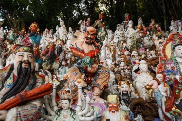This picture taken on August 9, 2016 shows a display of unwanted statues of deities, gathered and repaired after their owners discarded them, on a rocky slope running down to the sea in Hong Kong. Religion and local customs permeate Hong Kong, where Buddhist and Taoist temples are common and incense offerings are regularly burned outside local businesses. Private homes often have a shrine to a local deity, with Christian churches and mosques also in the mix. But with space at a premium in a city were rents are sky high, informal collections of discarded gods often decorate roadsides and public spaces. / AFP PHOTO / Anthony WALLACE / To go with "HONG KONG-CULTURE-LIFESTYLE-RELIGION", FEATURE by Dennis Chong