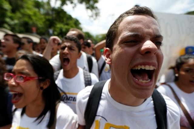 Estudiantes protestan durante un mitín exigiendo un alza en la financiación de la universidad y en contra del Presidente Nicolás Maduro, en Caracas, Venezuela, 26 de Mayo, 2016. Cientos de jóvenes se manifestaban el lunes en la ciudad fronteriza venezolana de San Cristóbal, quemando basura y bloqueando vías, en la más reciente protesta contra la suspensión del referendo para remover al presidente Nicolás Maduro.REUTERS/Carlos Garcia Rawlins - RTX2EDJQ