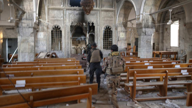Soldados iraquíes de las Fuerzas Especiales ingresan a una iglesia destruida por el EI en Bartella, al este de Mosul.
