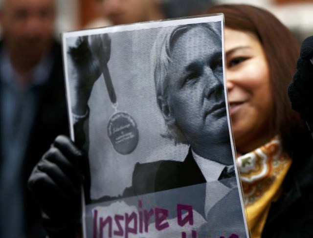 A supporter of Julian Assange holds a poster after prosecutor Ingrid Isgren from Sweden arrived at Ecuador's embassy to interview him in London, Britain, November 14, 2016. REUTERS/Peter Nicholls