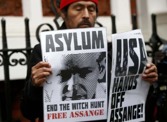 A supporter of Julian Assange holds posters after prosecutor Ingrid Isgren from Sweden arrived at Ecuador's embassy to interview him in London, Britain, November 14, 2016. REUTERS/Peter Nicholls