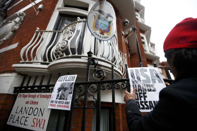 A supporter of Julian Assange attaches a poster to railings after prosecutor Ingrid Isgren from Sweden arrived at Ecuador's embassy to interview him in London, Britain, November 14, 2016. REUTERS/Peter Nicholls