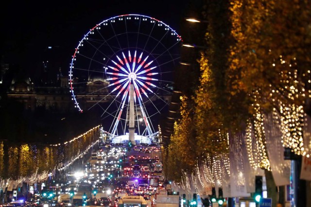 Christmas holiday lights hang from trees to illuminate Champs Elysees avenue in Paris as rush hour traffic fills the avenue leading down to the Giant Ferris Wheel at place de la Concorde in Paris, France, November 21, 2016. REUTERS/Charles Platiau