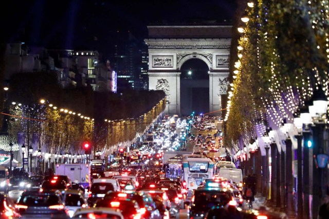 Christmas holiday lights hang from trees to illuminate the Champs Elysees avenue in Paris as rush hour traffic fills the avenue leading up to the Arc de Triomphe, France, November 21, 2016. REUTERS/Charles Platiau