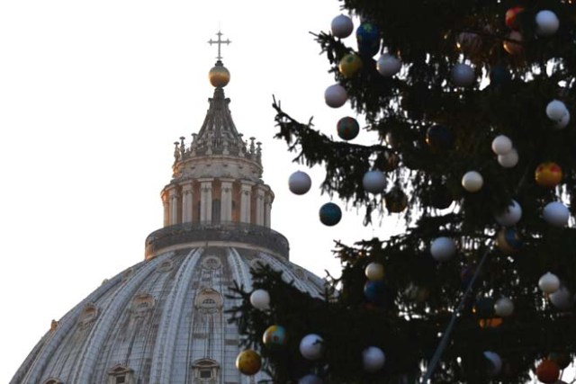The Saint Peter dome is seen beside a Christmas tree displayed at the Saint Peter square on December 9, 2016. This year, the Christmas ornaments were made by children of the paediatric oncology departments of Italian hospitals. / AFP PHOTO / VINCENZO PINTO