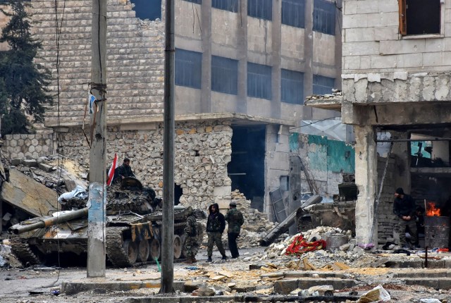 Syrian pro-government forces advance in the Jisr al-Haj neighbourhood during the ongoing military operation to retake remaining rebel-held areas in the northern embattled city of Aleppo on December 14, 2016. Shelling and air strikes sent terrified residents running through the streets of Aleppo as a deal to evacuate rebel districts of the city was in danger of falling apart. / AFP PHOTO / George OURFALIAN