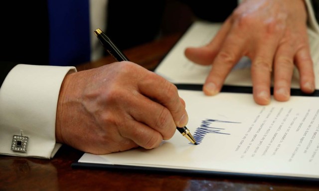 U.S. President Donald Trump signs an executive order to advance construction of the Keystone XL pipeline at the White House in Washington January 24, 2017. REUTERS/Kevin Lamarque