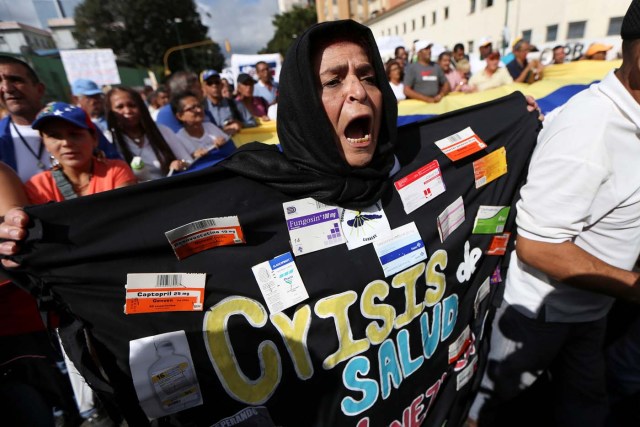 A woman wearing a costume with medicine boxes that reads "Health crisis" shouts slogans during a rally of workers of the health sector due to the shortages of basic medical supplies and against Venezuelan President Nicolas Maduro's government in Caracas, Venezuela February 7, 2017. REUTERS/Carlos Garcia Rawlins