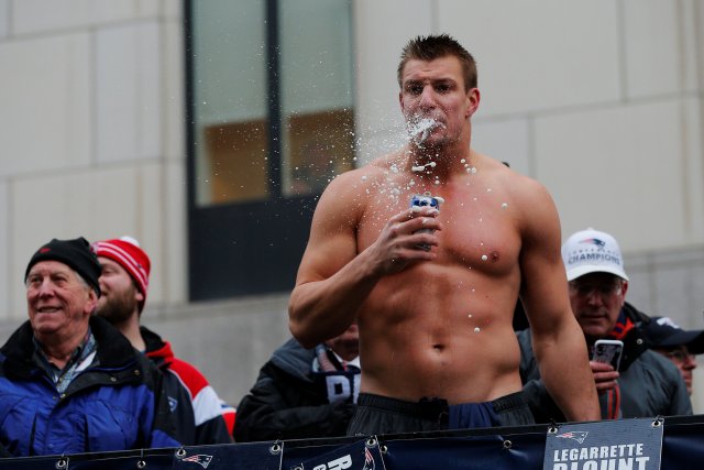 New England Patriots tight end Rob Gronkowski drinks a beer thrown to him from the crowd during the Patriots victory parade through the streets of Boston after winning Super Bowl LI, in Boston