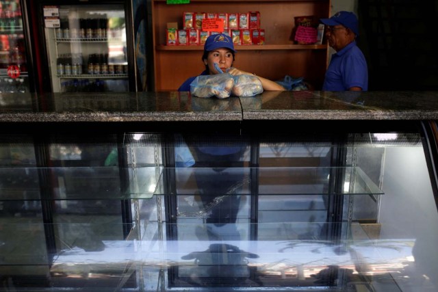 A saleswoman holds bags of bread as she waits for customers at bakery in Caracas, Venezuela March 17, 2017. REUTERS/Marco Bello