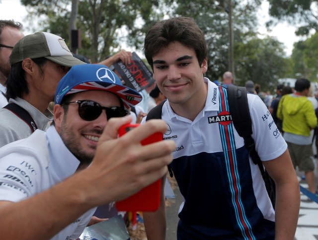 Formula One - F1 - Australian Grand Prix - Melbourne, Australia - 26/03/2017 Williams driver Lance Stroll (R) poses for a selfie with a fan as he arrives at the track. REUTERS/Jason Reed