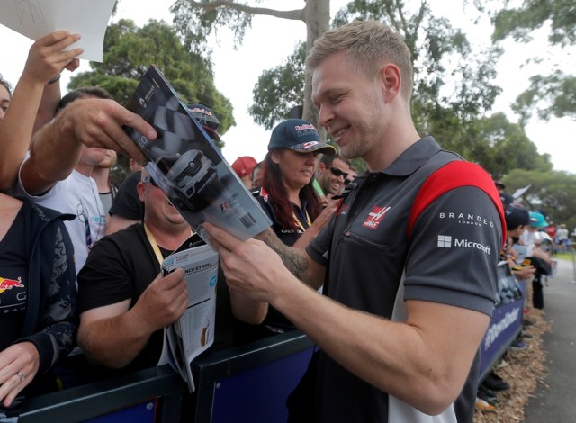 Formula One - F1 - Australian Grand Prix - Melbourne, Australia - 26/03/2017 Haas driver Kevin Magnussen of Denmark signs an autograph as he arrives at the track. REUTERS/Jason Reed