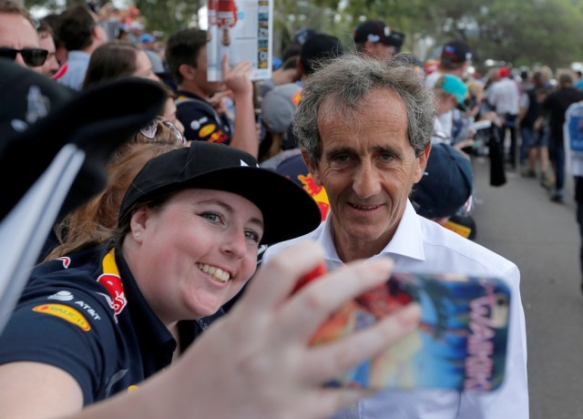 Formula One - F1 - Australian Grand Prix - Melbourne, Australia - 26/03/2017 Former Formula One world champion Alain Prost of France takes a selfie as he arrives at the track. REUTERS/Jason Reed