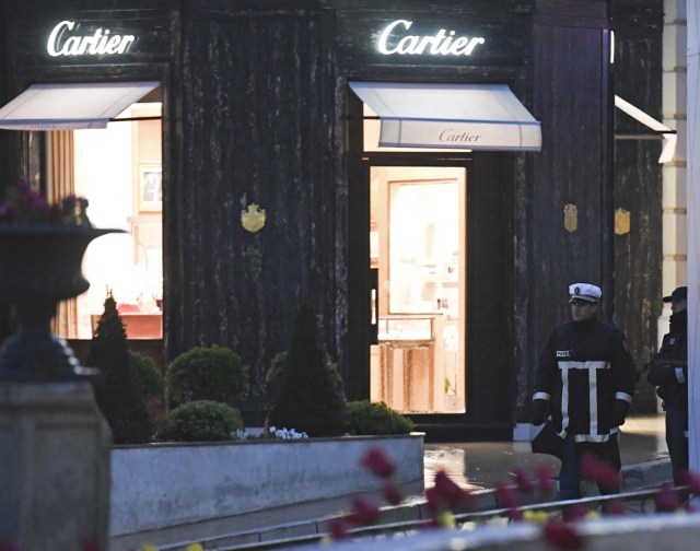 Monaco's police officers stand guard in front of the Cartier jewellery boutique after it was robbed in downtown Monaco on March 25, 2017. Monaco police were hunting for two suspects on March 25 after a daring afternoon robbery at the famous French jeweller Cartier, prompting a brief lockdown of the tiny principality and jet set haven. / AFP PHOTO / Yann COATSALIOU