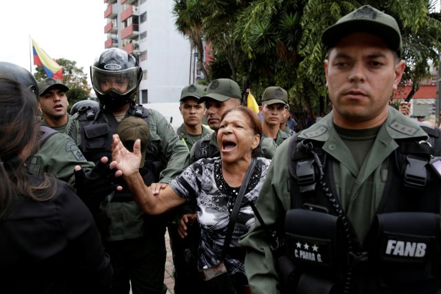 A pro-government supporter shouts slogans to opposition supporters and deputies of Venezuelan coalition of opposition parties (MUD) during a protest outside the Supreme Court in Caracas