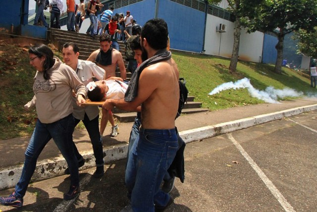 A demonstrator injured after riot police fired tear gas and rubber bullets at students opposing Venezuelan President Nicolas Maduro who were marching to protest in San Cristobal is carried away by other protesters, in San Ceistobal, Venezuela on April 5, 2017. University students and police clashed Wednesday during a protest in the Venezuelan city of San Cristobal (western border with Colombia), with a balance of at least a dozen injured. / AFP PHOTO / George Castellanos
